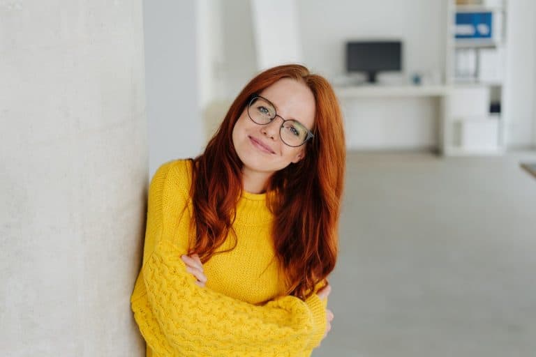 beautiful woman with red long hair, eye glasses, wearing a yellow sweater