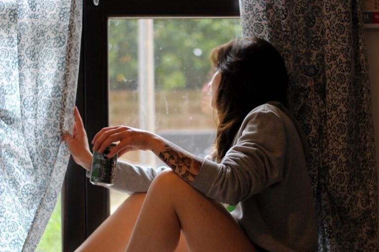woman with long hair looking out the window