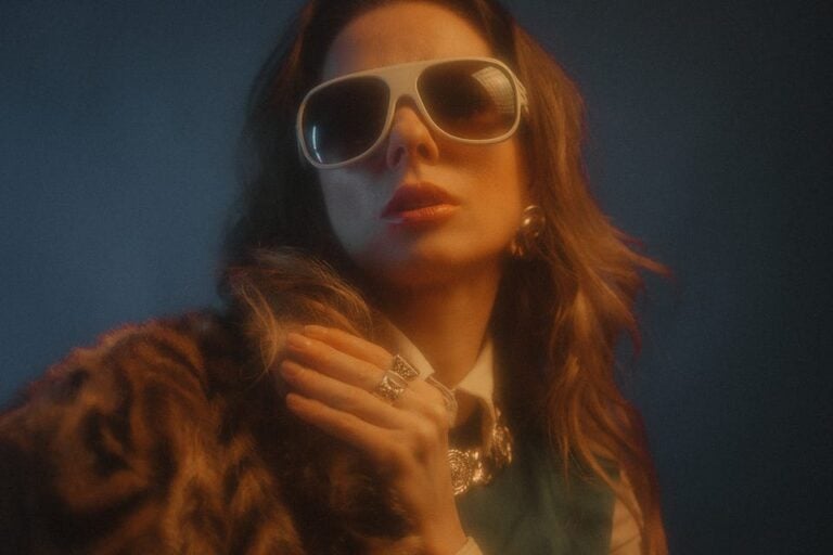 woman with long hair with sunglasses and expensive clothes