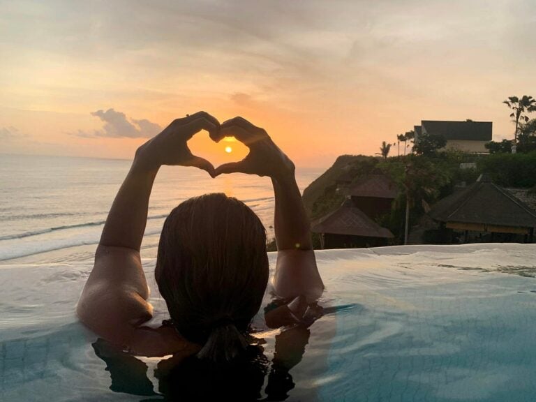 woman in a pool at sunset thanking karma