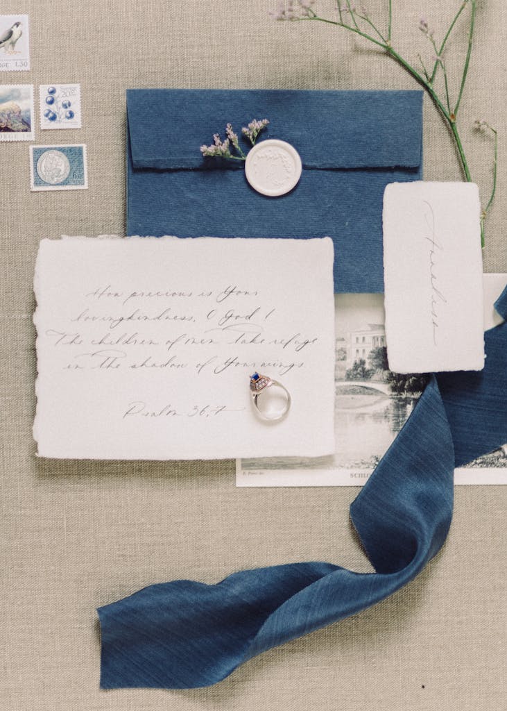 A vintage flat lay featuring blue envelopes, handwriting, and floral decorations for a classic touch.