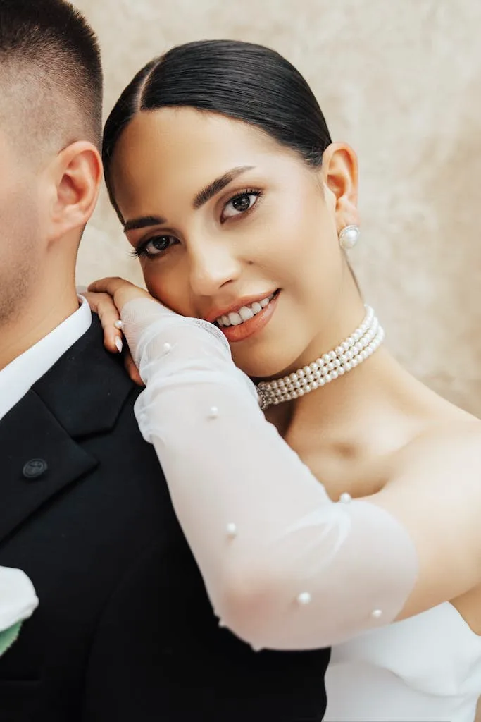Close-up of a smiling bride with pearl jewelry, leaning on her groom in Antalya.