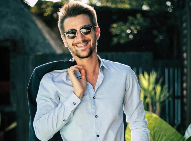 Confident young man in a stylish suit outdoors, exuding charm and elegance.