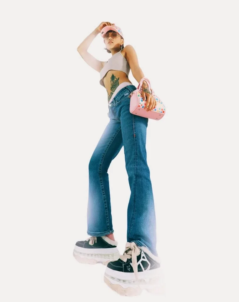 Stylish fashion shoot showcasing jeans, tattoos, and quirky accessories.