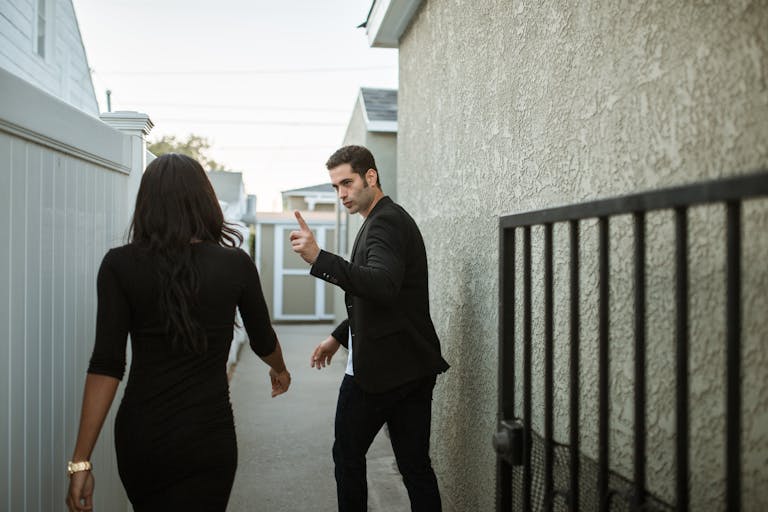 A couple having a tense argument in an outdoor alley, showcasing relationship conflict.