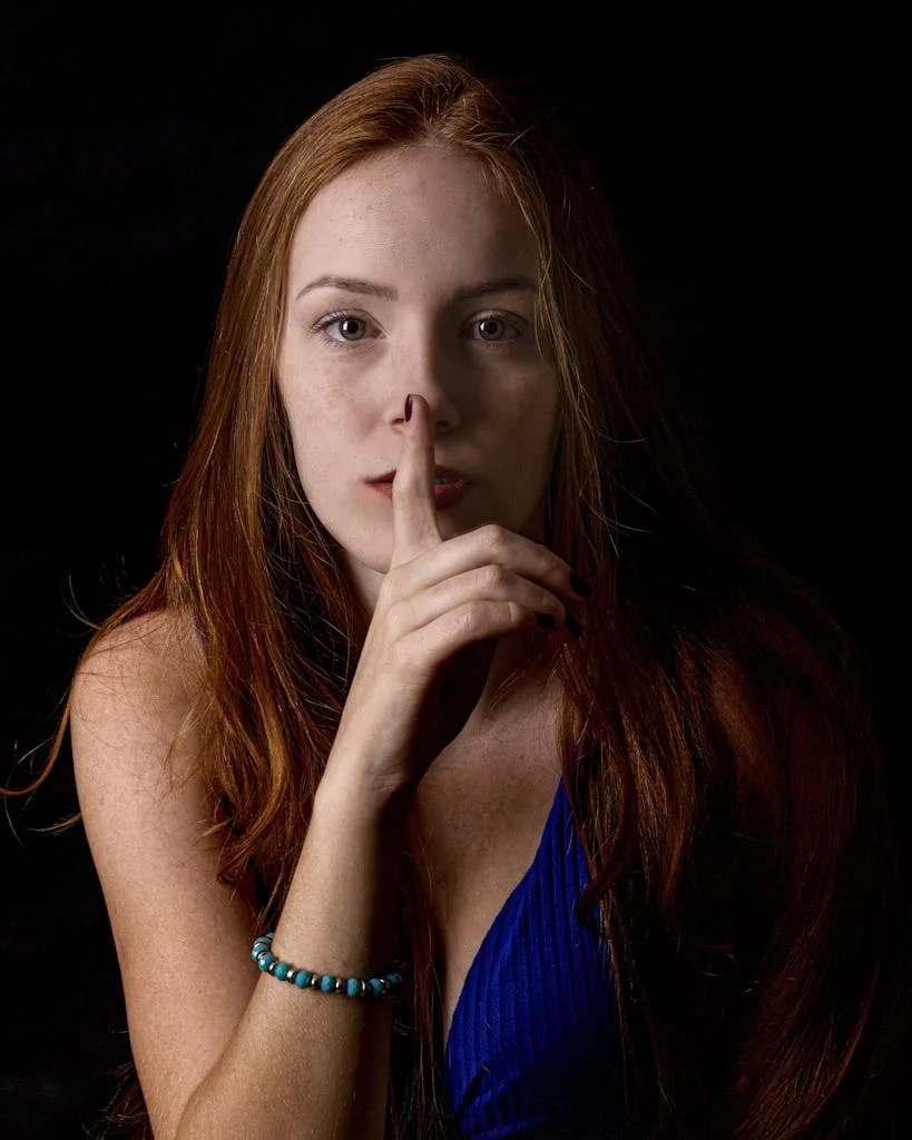Captivating portrait of a woman making a silence gesture with her finger.