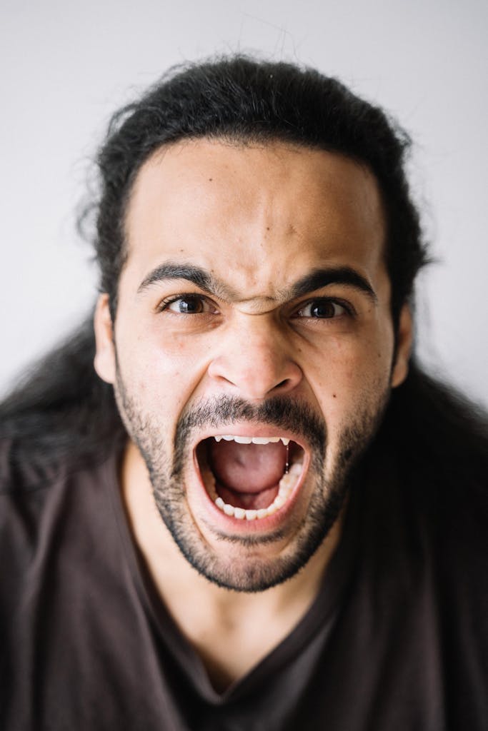 Close-up portrait of a man with a fierce expression, showcasing intense emotion and energy.