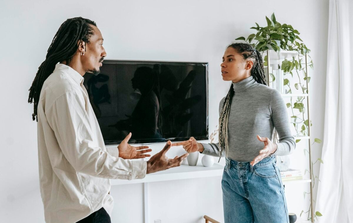 Young couple discussing relationship issues in a modern living room setting.