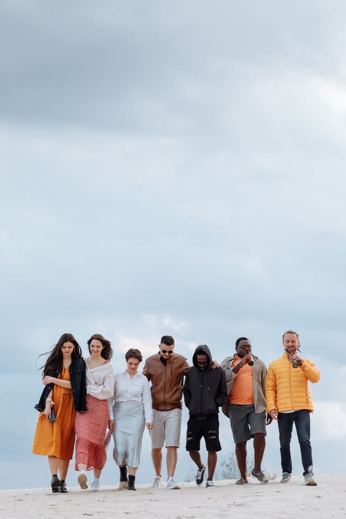 A diverse group of friends enjoying a walk under a cloudy sky, depicting unity and leisure.