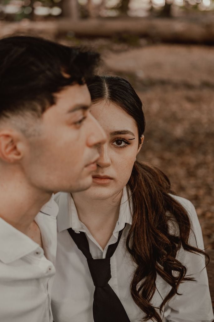 A young couple in a moment of reflection outdoors, expressing emotion and connection.