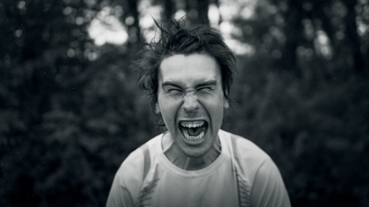 Close-up of a man expressing intense emotion, captured in black and white for a dramatic effect.