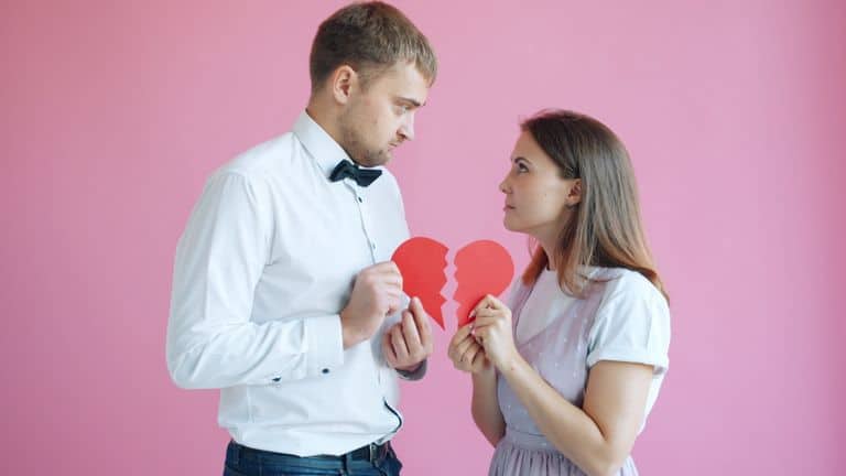A couple holding a broken heart symbolizing a relationship problem or breakup.