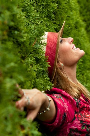 A joyful woman enjoying nature, embracing freedom in a lush green park.
