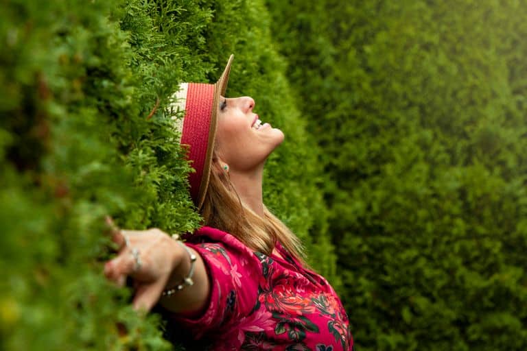 A joyful woman enjoying nature, embracing freedom in a lush green park.