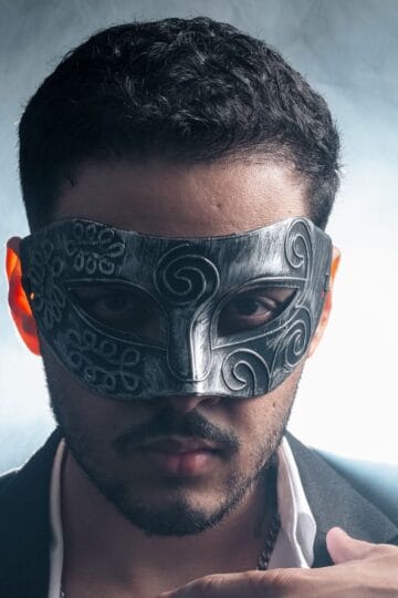 A man wearing an intricate mask and suit, exuding a mysterious and stylish aura.