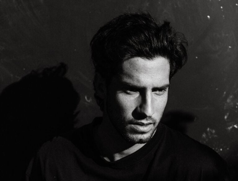 Black and white of unshaven adult male with thoughtful gaze in casual wear looking away