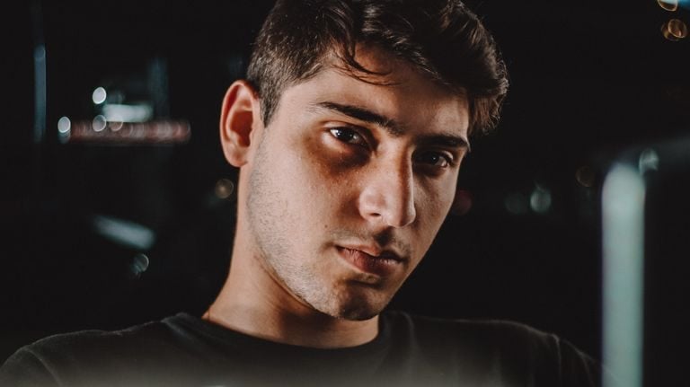Close-up moody portrait of a young man with intense gaze captured at night.