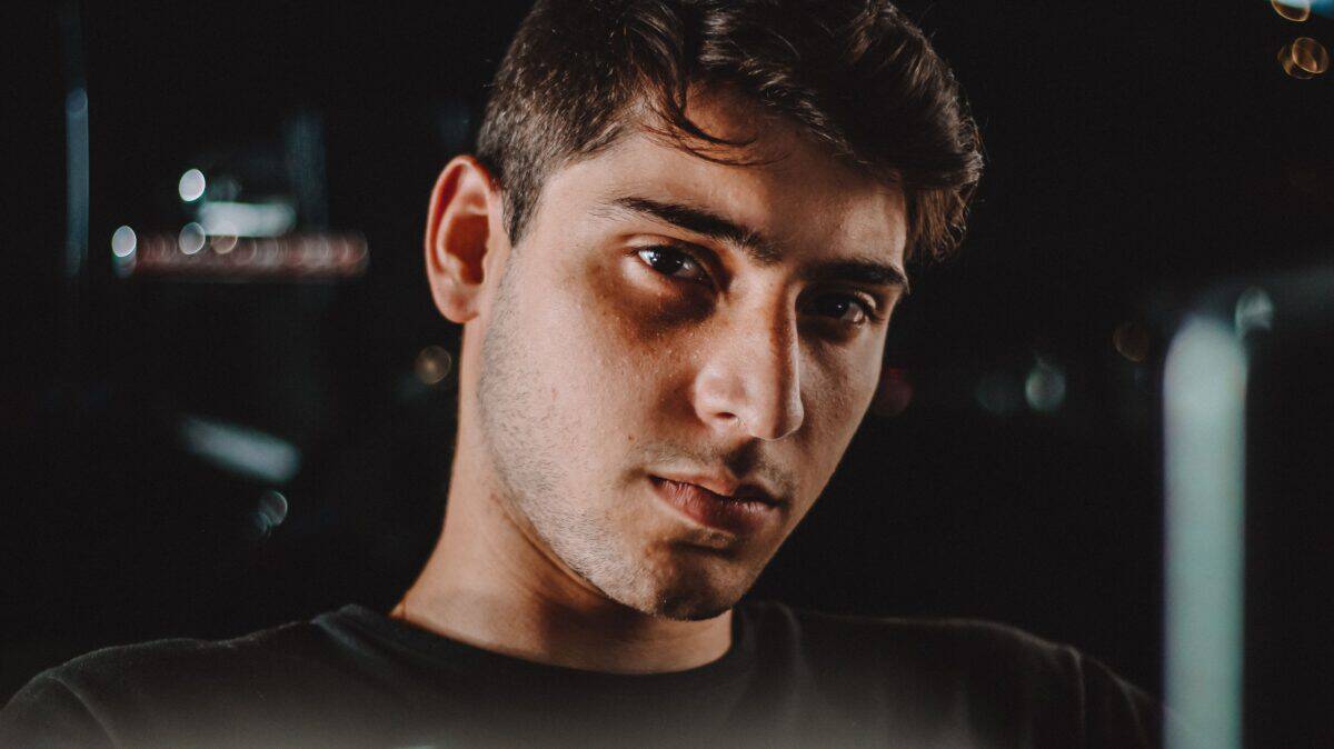 Close-up moody portrait of a young man with intense gaze captured at night.