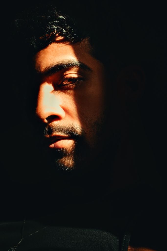 Expressive portrait of a man with dramatic lighting and shadows on his face.