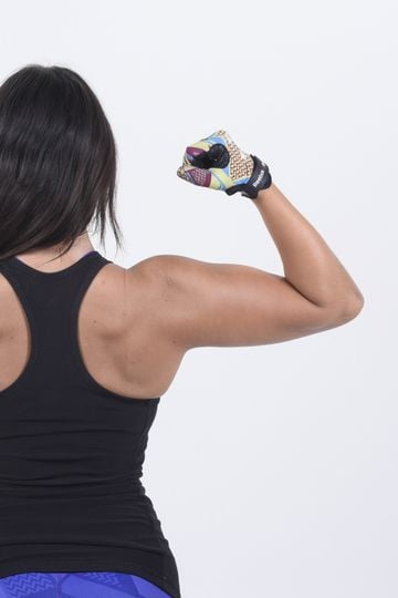 Young woman showing her strength and fitness in a studio setting.
