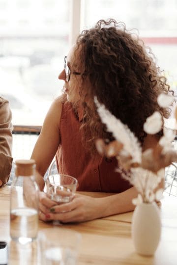 A friendly discussion among colleagues in a cozy cafe environment, fostering teamwork and collaboration.